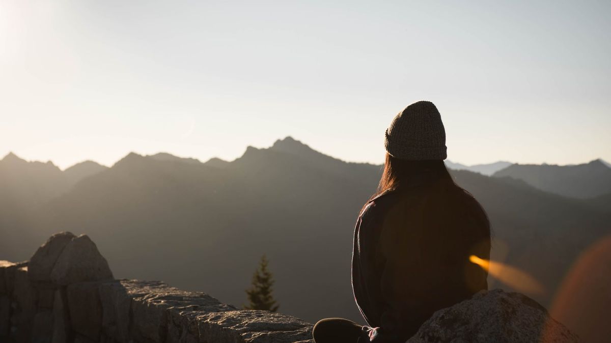 mujer meditando en las montañas.