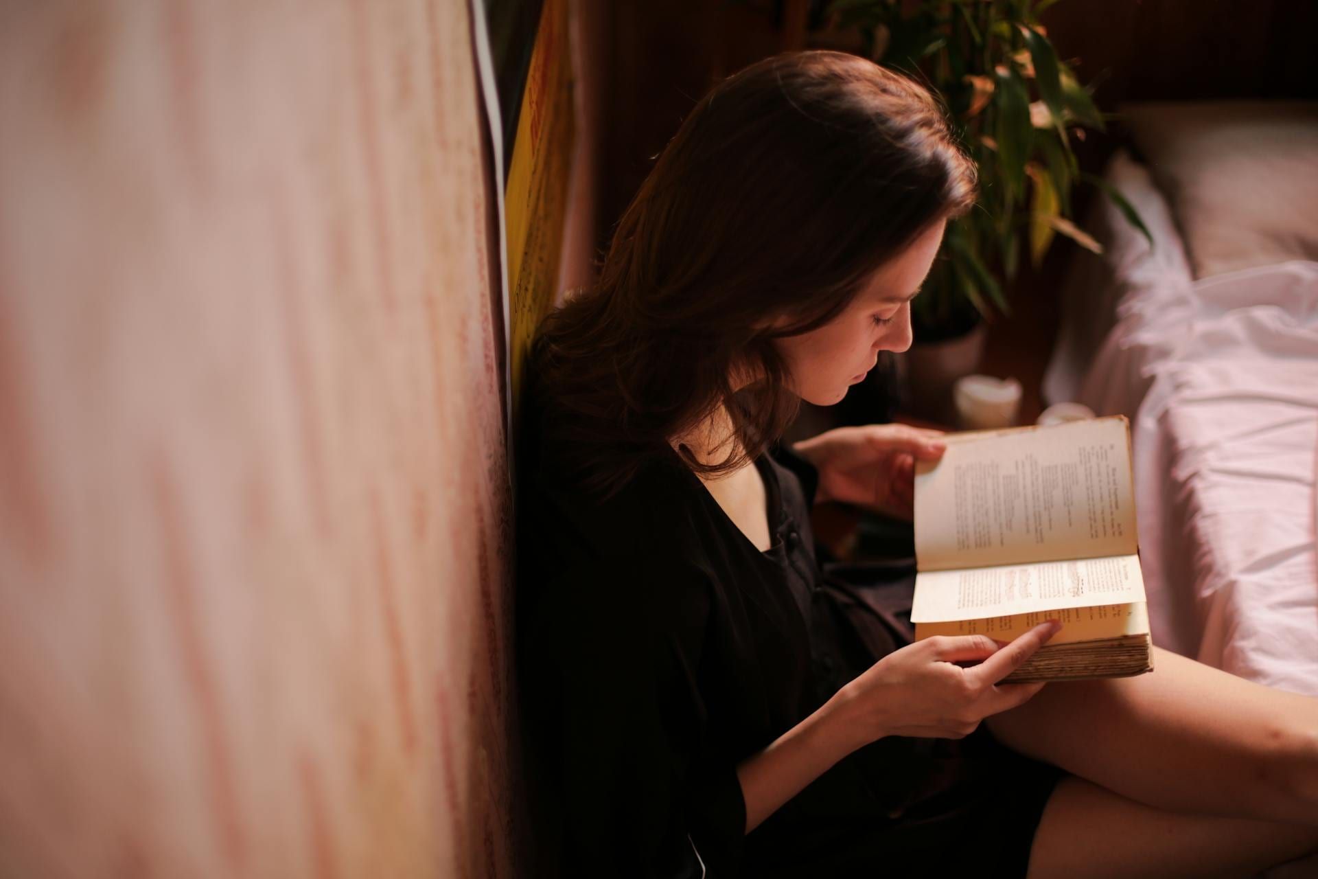 Mujer leyendo un libro como actividad relajante por la noche para conciliar el sueño.