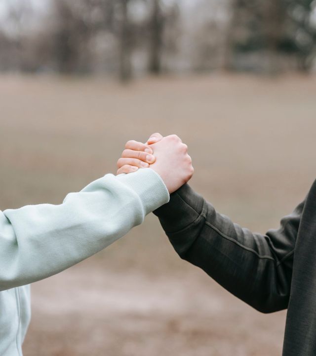 Dos personas se dan la mano en señal de apoyo