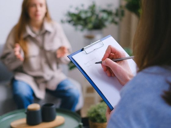 Terapeuta tomando notas durante una entrevista con una paciente