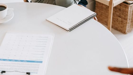 Dos personas conversando en una mesa con café y documentos